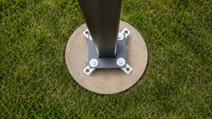 Light pole base with anchor bolt adapter installed on a concrete footing