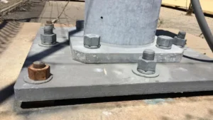 Light pole base with anchor bolts installed in an existing concrete footing