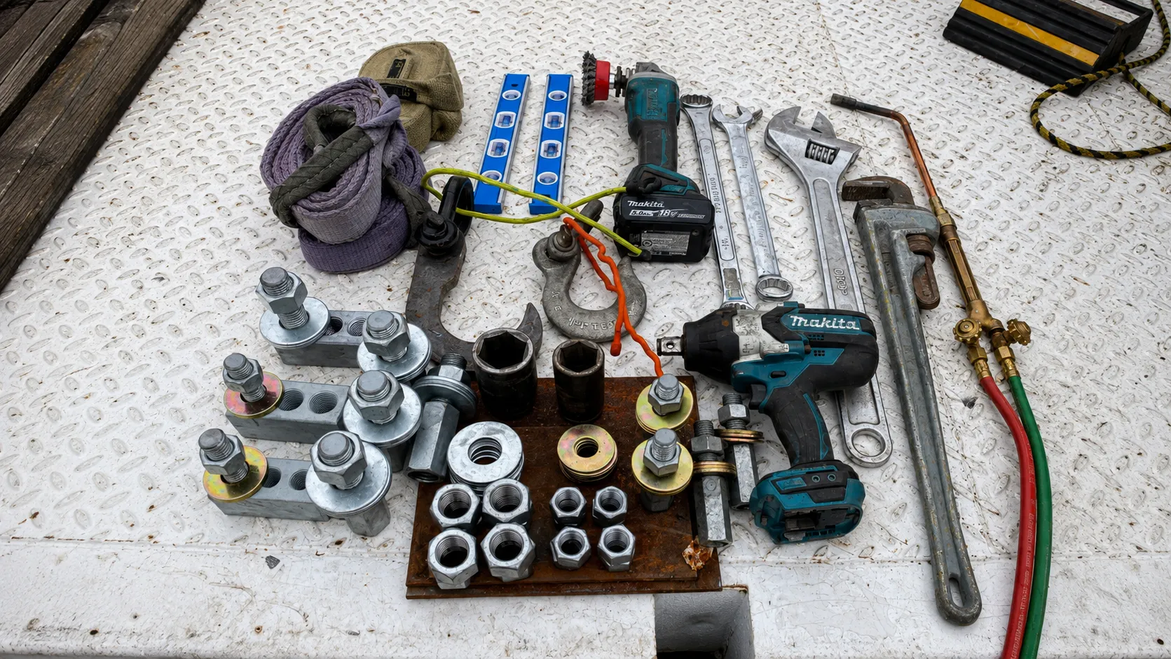 Light pole replacement tools including wrenches, impact driver, levels, lifting straps, sockets, and anchor bolt hardware