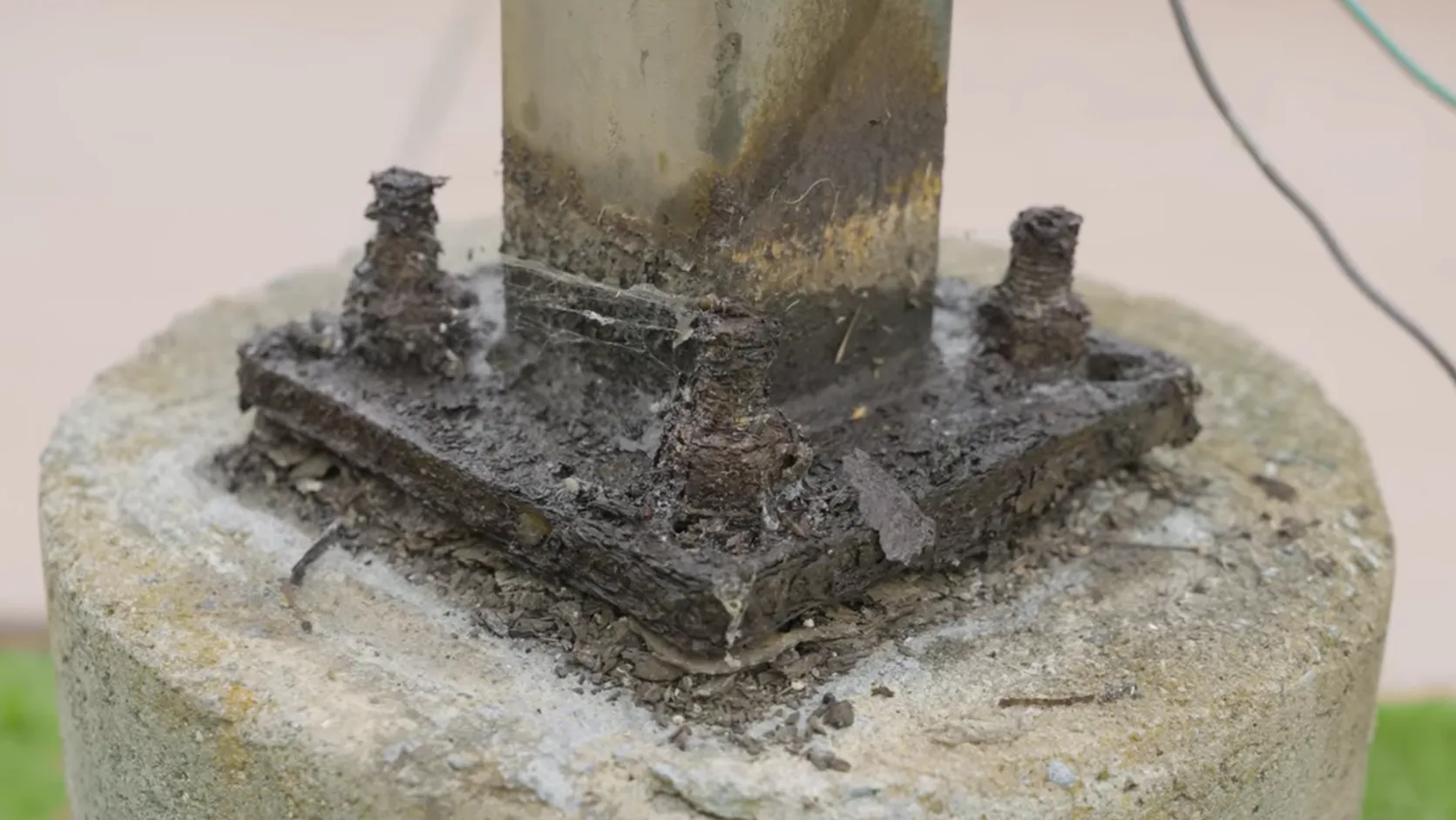 Severely rusted anchor nuts and anchor bolts at the base of a light pole